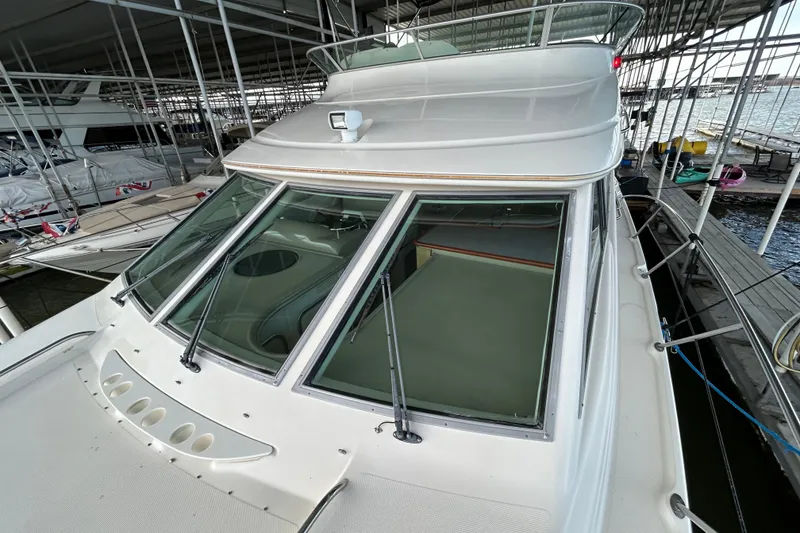 Slide: The Image of 1999 Maxum 4600 SCB yacht docked in a marina under a metal canopy. - 41