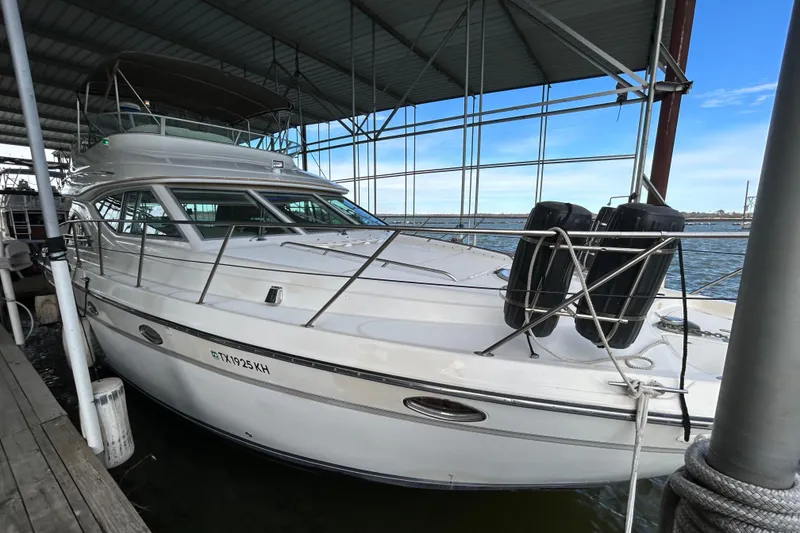 Slide: The Image of 1999 Maxum 4600 SCB yacht docked under a covered marina, side view. - 6