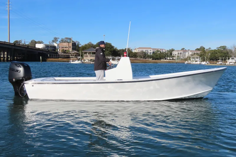 Slide: The Image of 1982 Privateer 20 Roamer Skiff on water, featuring Suzuki outboard motor. - 10