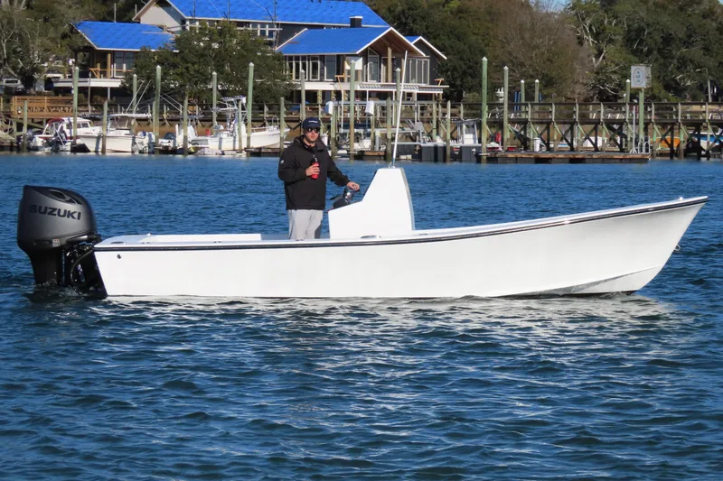 Slide: The Image of 1982 Privateer 20 Roamer Skiff on water with Suzuki outboard motor. - 12