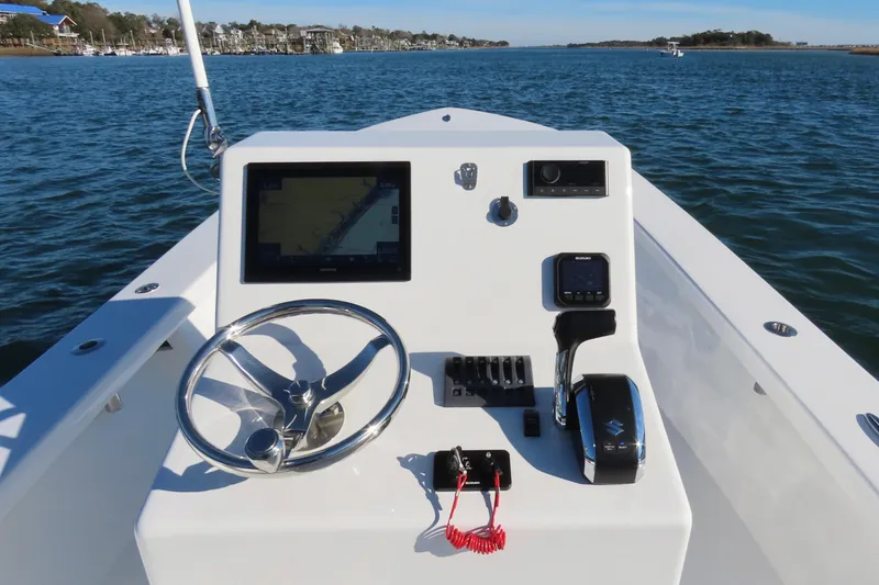 Slide: The Image of Steering console of a 1982 Privateer 20 Roamer Skiff on open water. - 18