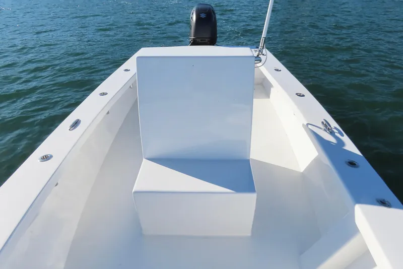 Slide: The Image of 1982 Privateer 20 Roamer Skiff on water, showcasing sleek white interior and outboard motor. - 20
