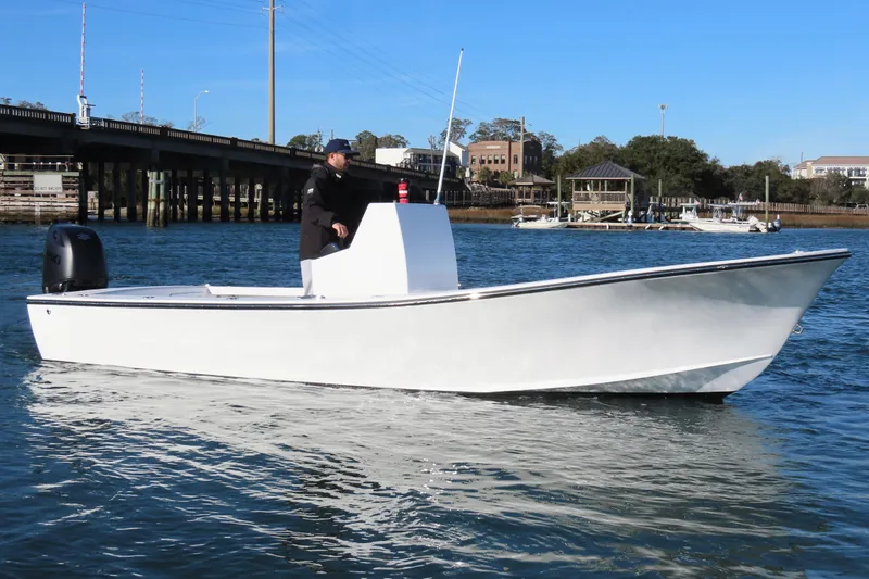 Slide: The Image of 1982 Privateer 20 Roamer Skiff on calm water, with a person at the helm. - 6