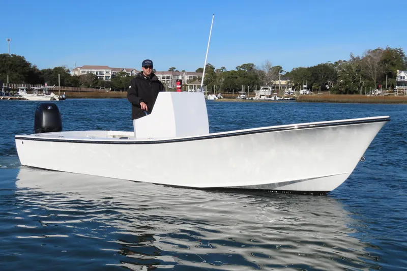 Slide: The Image of 1982 Privateer 20 Roamer Skiff on calm water, with a person steering. - 8