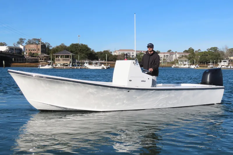 Slide: The Image of 1982 Privateer 20 Roamer Skiff on calm water, with a person at the helm. - 9