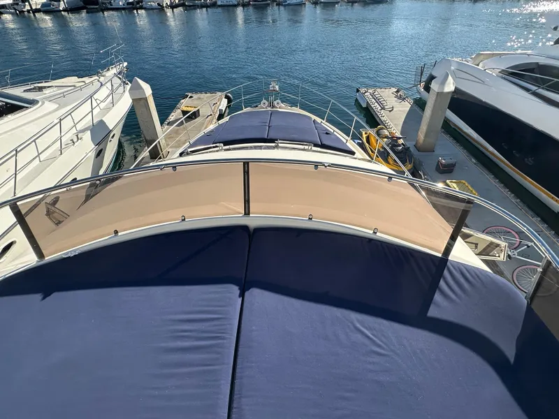 Slide: The Image of Aicon 56 Flybridge yacht, 2003 model, docked at marina with blue sunbeds. - 10