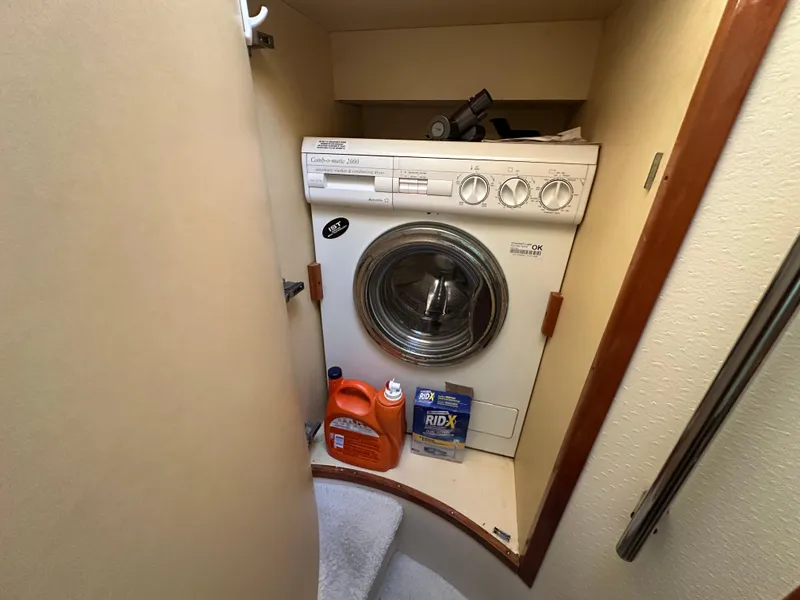 Slide: The Image of Laundry area with washer and cleaning supplies on Aicon 56 Flybridge yacht, 2003 model. - 16