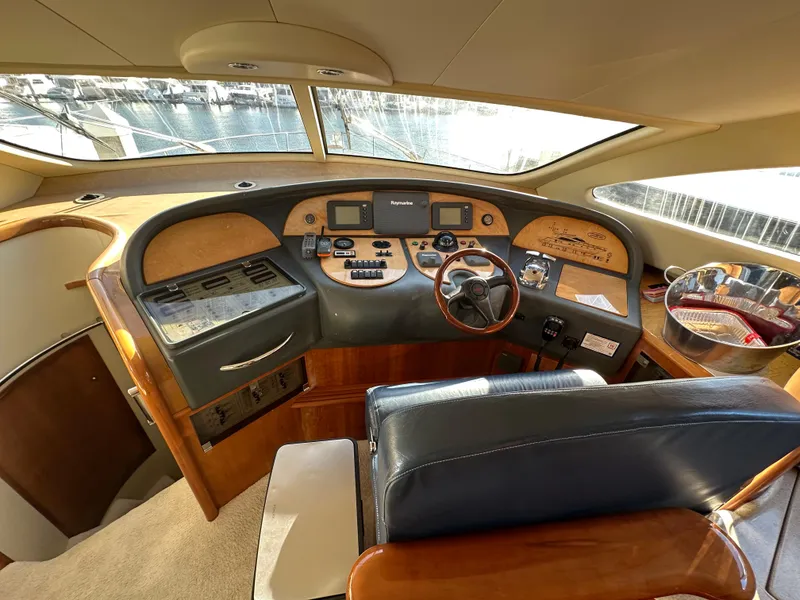Slide: The Image of Interior cockpit of 2003 Aicon 56 Flybridge yacht with wooden dashboard and leather seating. - 23