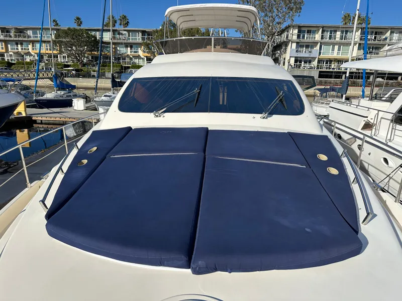 Slide: The Image of Aicon 56 Flybridge yacht, 2003 model, with blue sun pads, docked at a marina. - 5