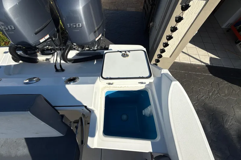 Slide: The Image of 2019 Blackfin 242 CC boat with twin Yamaha 150 engines and open storage compartment. - 10