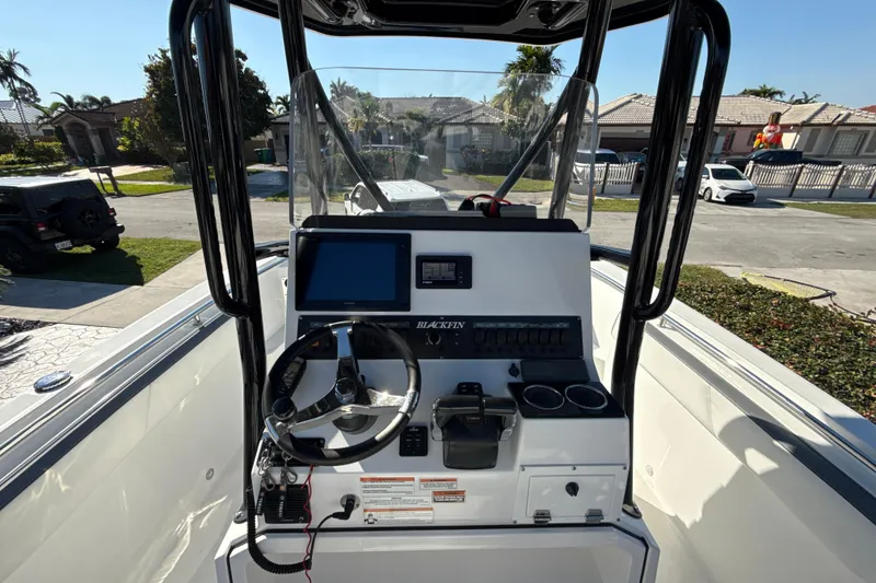 Slide: The Image of 2019 Blackfin 242 CC boat console with steering wheel and navigation display. - 11