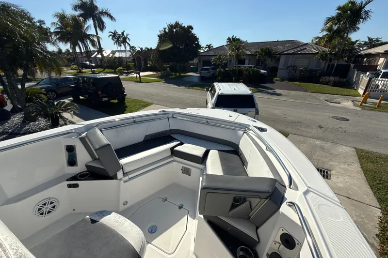 Slide: The Image of 2019 Blackfin 242 CC boat with seating, parked in a residential neighborhood. - 14