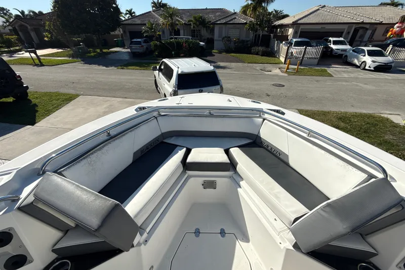 Slide: The Image of 2019 Blackfin 242 CC boat with spacious seating, parked in a residential driveway. - 15
