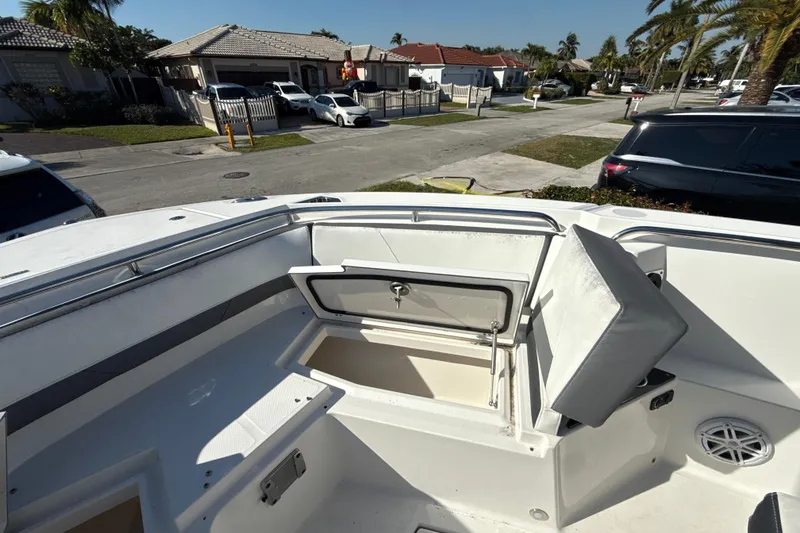 Slide: The Image of 2019 Blackfin 242 CC boat with open storage compartment, parked in a residential area. - 17