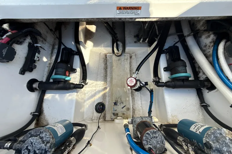Slide: The Image of 2019 Blackfin 242 CC boat engine compartment with pumps and wiring. - 26