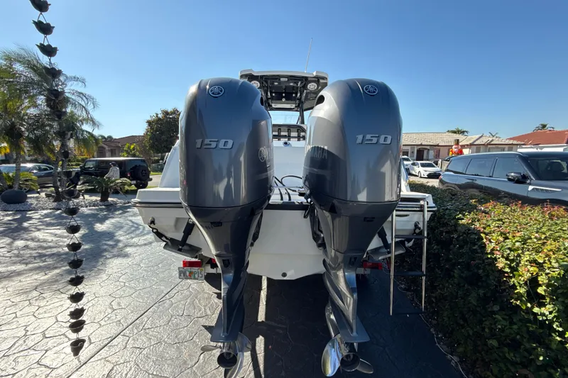 Slide: The Image of 2019 Blackfin 242 CC boat with dual Yamaha 150 engines, parked in a driveway. - 3