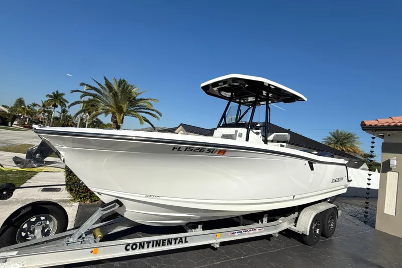 Slide: The Image of 2019 Blackfin 242 CC boat on trailer, parked in sunny residential area. - 4