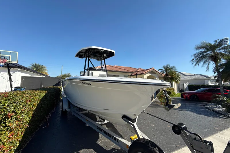 Slide: The Image of 2019 Blackfin 242 CC boat on trailer in sunny residential driveway. - 5