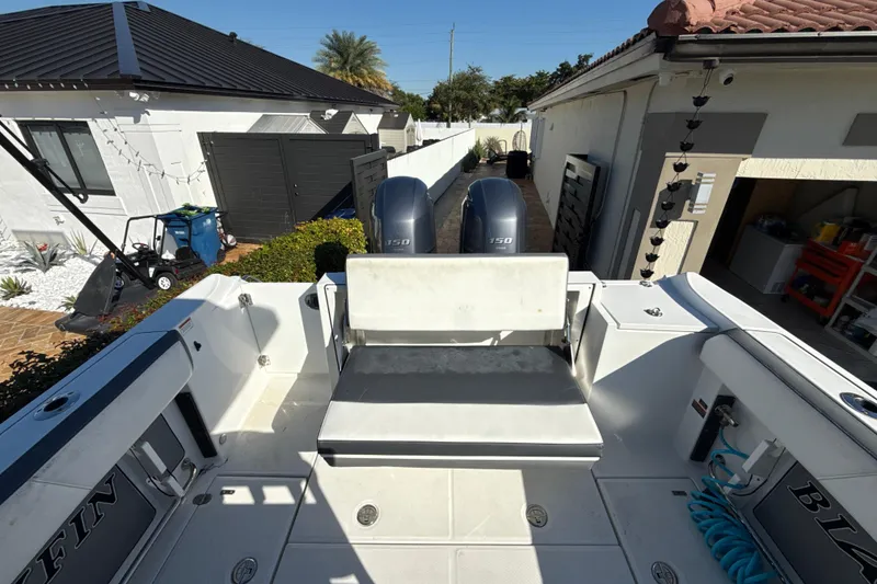 Slide: The Image of 2019 Blackfin 242 CC boat with dual engines in a residential driveway. - 9