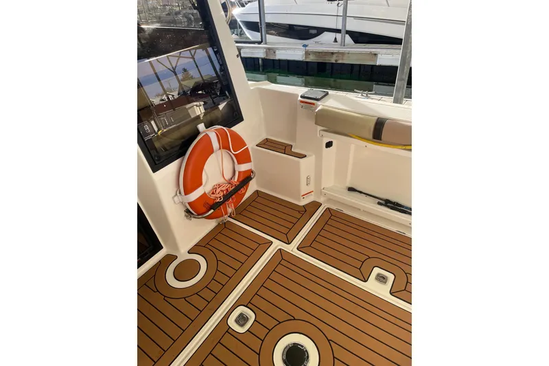 Slide: The Image of 2019 Ranger Tugs R-27 boat interior with teak flooring and life preserver. - 23