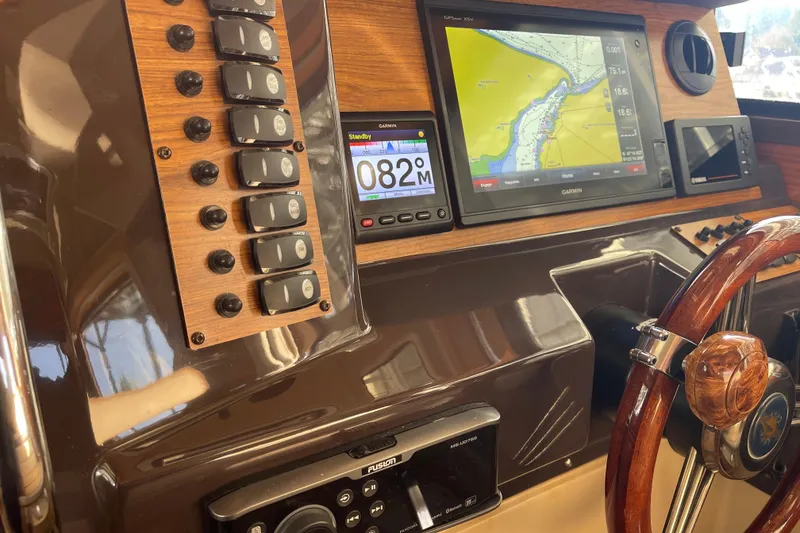 Slide: The Image of 2019 Ranger Tugs R-27 dashboard with navigation system and wooden steering wheel. - 35