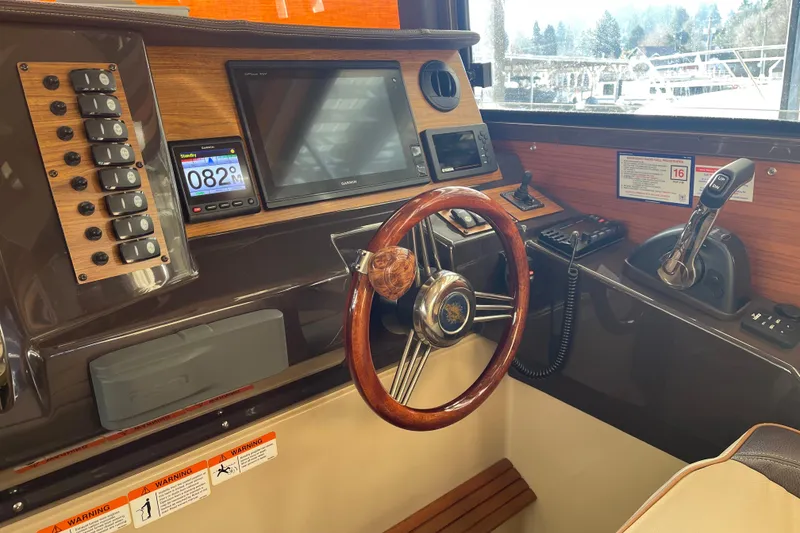 Slide: The Image of 2019 Ranger Tugs R-27 helm with wooden steering wheel and modern navigation equipment. - 36