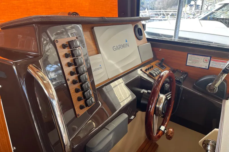 Slide: The Image of 2019 Ranger Tugs R-27 helm with Garmin navigation system and wooden steering wheel. - 37