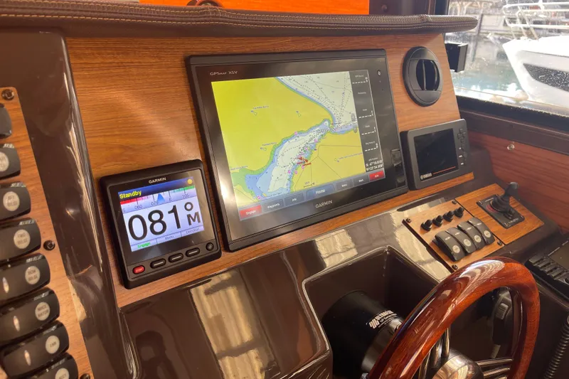 Slide: The Image of 2019 Ranger Tugs R-27 helm with Garmin navigation system and wooden steering wheel. - 38
