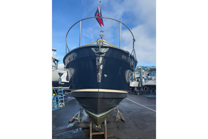 Slide: The Image of 2019 Ranger Tugs R-27 boat on dry dock, front view with flag. - 44