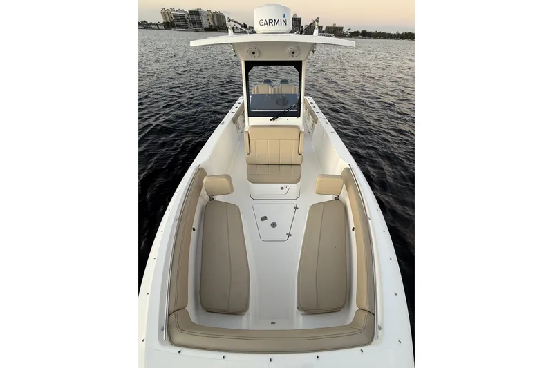 Slide: The Image of 2021 Pursuit S 268 Sport boat with beige seating on calm water. - 18