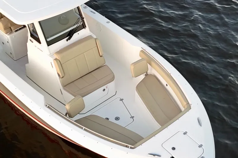 Slide: The Image of 2021 Pursuit S 268 Sport boat with beige seating on calm water. - 20