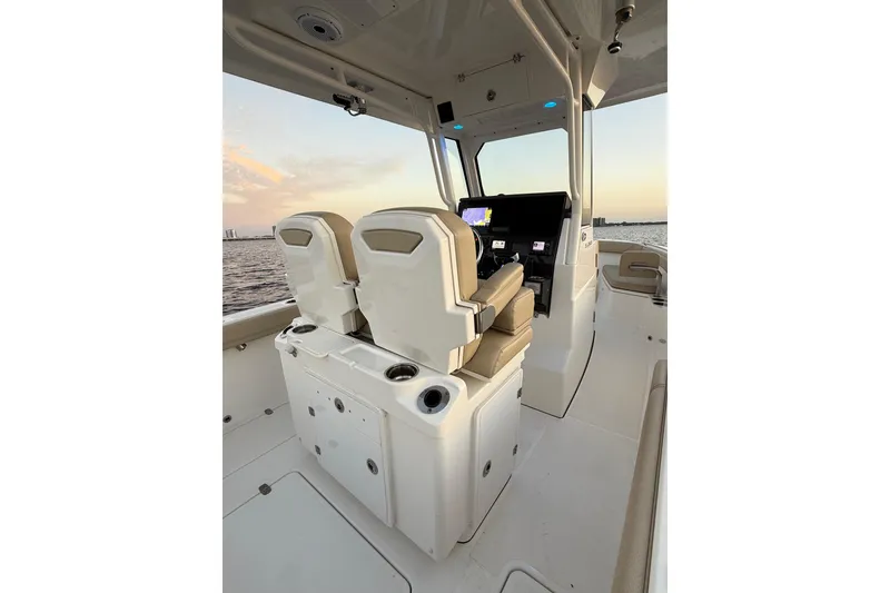 Slide: The Image of 2021 Pursuit S 268 Sport boat interior with dual seats and control panel at sunset. - 26