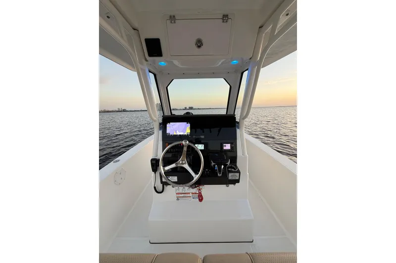 Slide: The Image of 2021 Pursuit S 268 Sport boat helm with steering wheel and navigation system at sunset. - 32