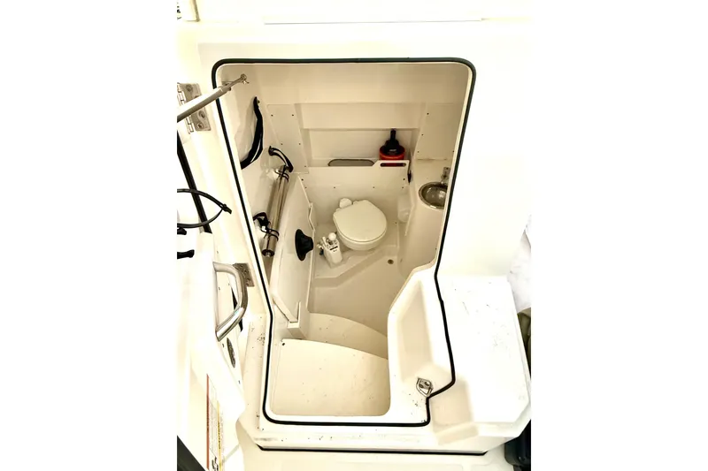Slide: The Image of 2021 Pursuit S 268 Sport boat interior with compact marine toilet and sink. - 33