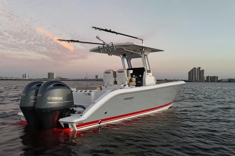 Slide: The Image of 2021 Pursuit S 268 Sport boat on water at sunset with city skyline. - 5