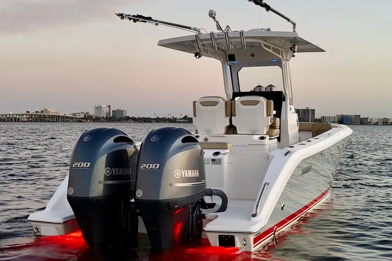 Slide: The Image of 2021 Pursuit S 268 Sport boat with dual Yamaha engines on calm water at sunset. - 9