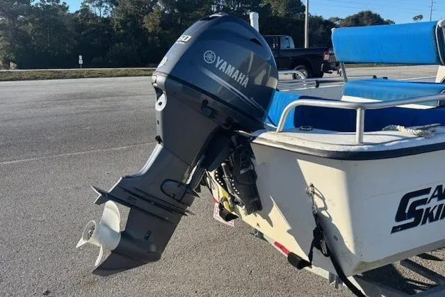 Slide: The Image of 2004 Carolina Skiff 17DLX boat with Yamaha outboard motor, parked on a sunny day. - 4