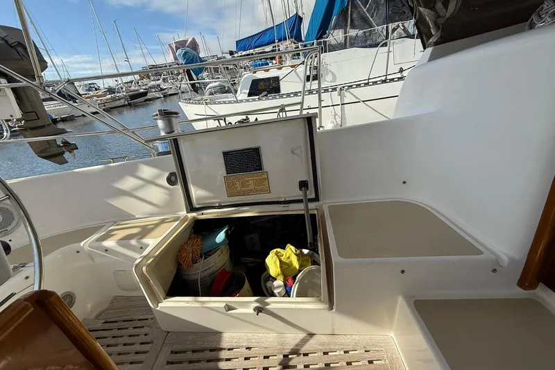Slide: The Image of Cabo Rico Cutter 45 (2000) cockpit with open storage compartment, docked at marina. - 13