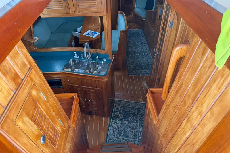 Slide: The Image of Interior of 2000 Cabo Rico Cutter 45 sailboat with wooden cabinetry and compact kitchen. - 20