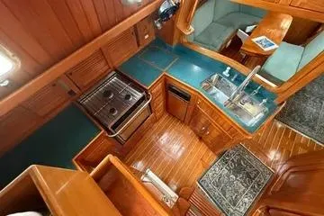 Slide: The Image of Interior of 2000 Cabo Rico Cutter 45 yacht with wooden cabinetry and compact kitchen. - 21