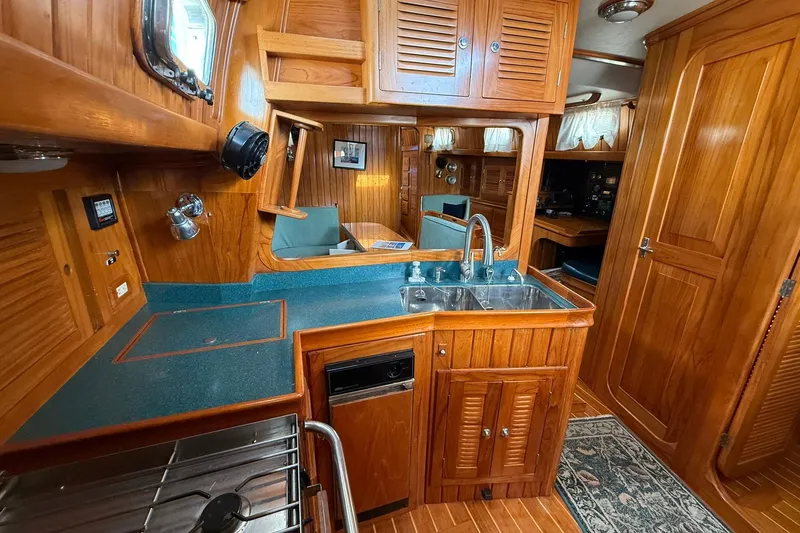Slide: The Image of Luxurious 2000 Cabo Rico Cutter 45 yacht interior with wooden cabinetry and modern kitchen amenities. - 22