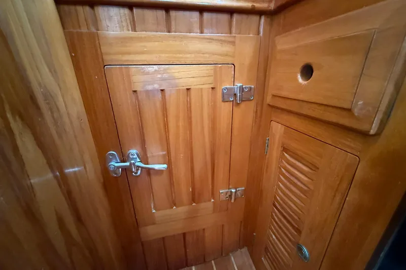 Slide: The Image of Wooden interior of 2000 Cabo Rico Cutter 45 sailboat, featuring cabinets and door. - 25