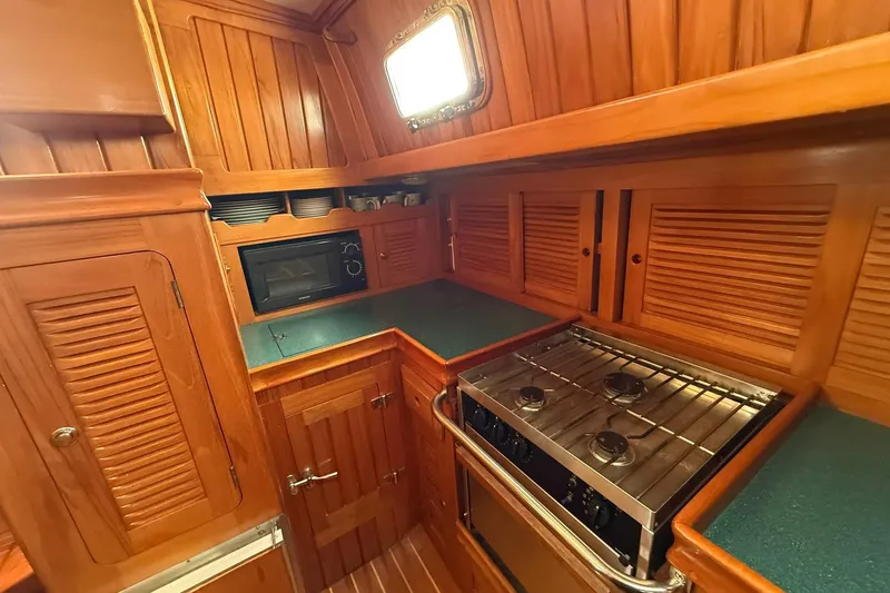 Slide: The Image of Cabo Rico Cutter 45 yacht kitchen with wooden cabinetry and modern appliances, 2000 model. - 26