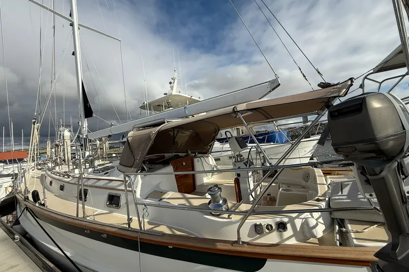 Slide: The Image of 2000 Cabo Rico Cutter 45 sailboat docked at marina under cloudy sky. - 3