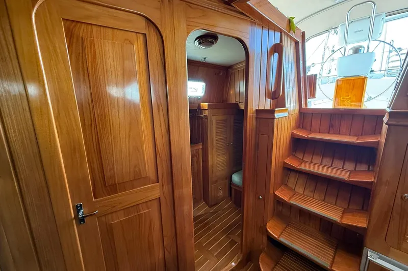 Slide: The Image of Interior of 2000 Cabo Rico Cutter 45 with polished wooden finish and staircase. - 30