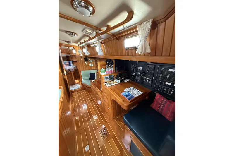 Slide: The Image of Luxurious interior of 2000 Cabo Rico Cutter 45 sailboat with wood paneling and navigation station. - 45