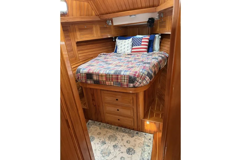 Slide: The Image of Cozy cabin interior of 2000 Cabo Rico Cutter 45 with wooden finish and plaid bedding. - 52