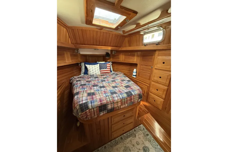 Slide: The Image of Cozy cabin interior of 2000 Cabo Rico Cutter 45 with wooden finish and plaid bedding. - 53
