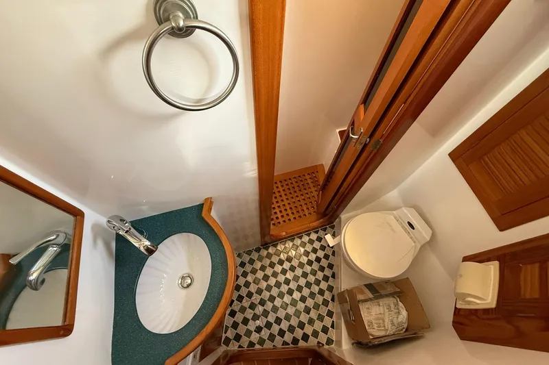 Slide: The Image of Compact bathroom in 2000 Cabo Rico Cutter 45 yacht with sink, toilet, and checkered floor. - 54