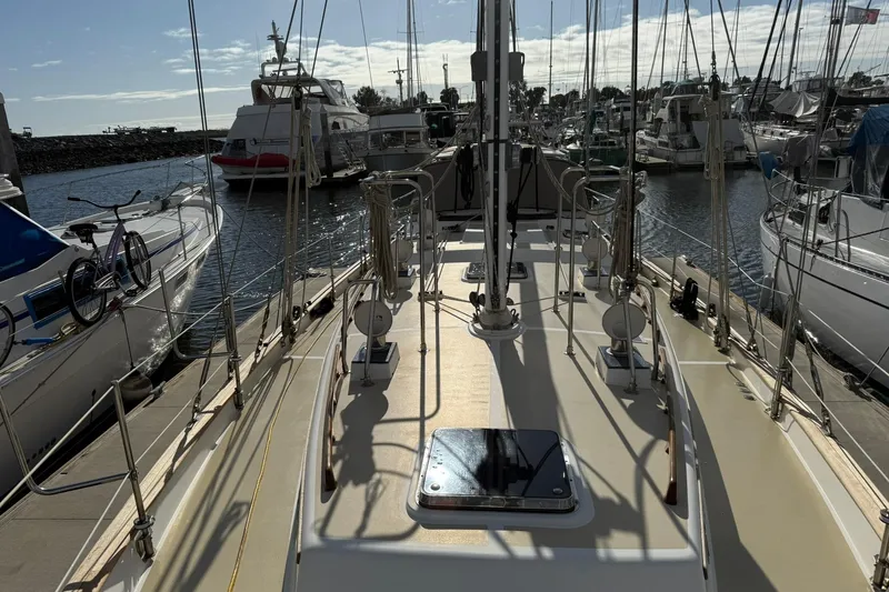 Slide: The Image of Cabo Rico Cutter 45 sailboat from 2000 docked in a marina, surrounded by other boats. - 8
